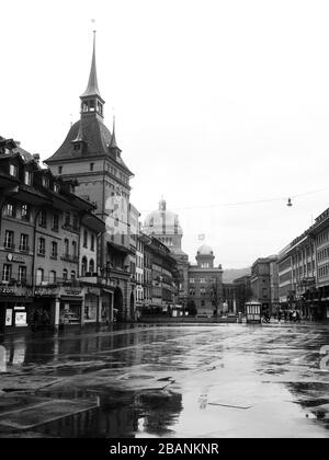 Schwarz-Weiß-Bild der mittelalterlichen Stadt Bern in der Schweiz mit Uhr aus dem 17. Jahrhundert im Hintergrund, Kirchturm und parlament. Stockfoto