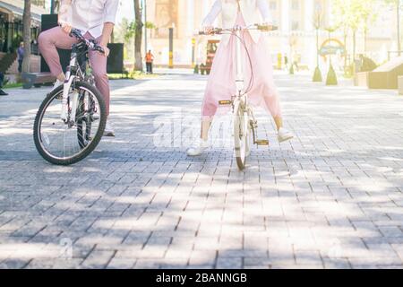 Junge Paare fahren an einem sonnigen Tag mit dem Fahrrad im Park Stockfoto