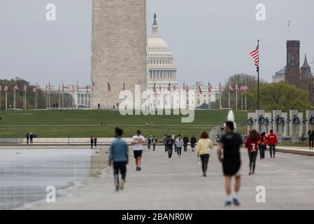 Washington DC, USA. März 2020. Am 28. März 2020 sind Menschen in der Nähe des Washington Monument in Washington, DC, den Vereinigten Staaten zu sehen. Die Vereinigten Staaten haben mehr als 2.000 COVID-19-Todesfälle gemeldet, so die neueste Tally vom Center for Systems Science and Engineering (CSSE) der Johns Hopkins University. Ab 18:40 Uhr am Samstag (2240 GMT) gab es in den Vereinigten Staaten mehr als 121.000 bestätigte Fälle mit 2.010 Todesfällen, eine interaktive Karte, die von der CSSE gepflegt wurde, zeigte. Credit: Ting Shen/Xinhua/Alamy Live News Stockfoto