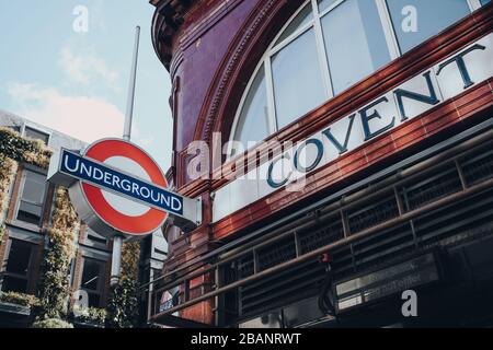 London, Großbritannien - 06. März 2020: U-Bahn-Rundel und Schild mit dem Namen der Station vor der Station Covent Garden. London Underground ist die älteste unterirdische rai Stockfoto