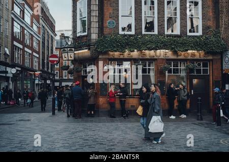 London, Großbritannien - 06. März 2020: Fassade des Pubs "Blue Posts" in Soho, einer Gegend von London, die für LGBTQ+ Bars, Restaurants und Clubs berühmt ist, Leute, die ou stehen Stockfoto