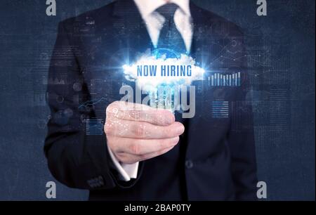 Geschäftsmann, der eine Glühbirne mit JETZT EINSTELLENDER Aufschrift hält, neues Geschäftskonzept Stockfoto