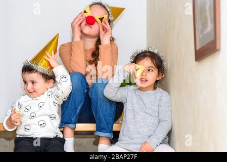 Drei Kinder feiern Purim.Children, die in der Geburtstagsparty zu Hause Plätzchen essen. Stockfoto