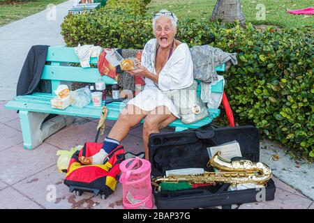 Miami Beach Florida, Lummus Park, obdachlose Frau, Frauen, Senioren Bürger, vagrant, Bank, Saxophon, Musikinstrument, Instrumente, FL11033104 Stockfoto