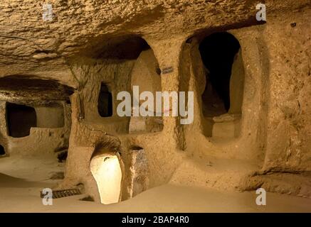 Ein runder Schlossstein, der in der Antike verwendet wurde, um Eindringlinge vom Betreten der unterirdischen Stadt Kaymakli in Kappadokien Region der Türkei zu blockieren. Stockfoto