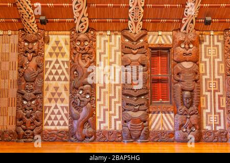 Traditionelle Maori-Schnitzereien im Inneren von Te Whare Runanga, dem Maori Meeting House, in Waitangi, North Island, Neuseeland. Stockfoto