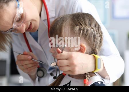 Pädiatrischer Zahnarzt untersucht Zähnewenig Mädchen Stockfoto