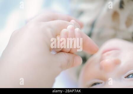 Nahaufnahme von Mutter und Baby, die die Hände halten Stockfoto