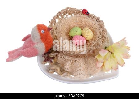 Ostern handgefertigtes Nest auf Tonplatte aus Seil und lustiger Vogel aus Schafwolle. Isoliert auf weißem Studio-Makro Stockfoto