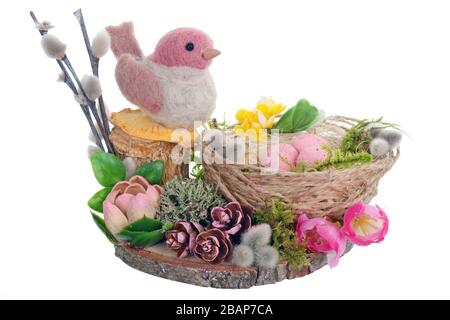 Handgefertigtes Osternest aus Seil und Moos mit pinkfarbenem lustigen Vogel aus Schafwolle. Isoliert auf weißem Studio-Makro Stockfoto