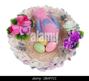 Ostern handgemachtes Gelege aus Seil mit blauem lustigen Vogel aus Schafsoh und gepunkteten Eiern. Isoliert auf weißem Studio-Makro Stockfoto