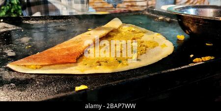 A Dosa ist ein aus Südindien stochiger, flacher, geschicherter Reissatter, der aus einem fermentierten Teig hergestellt wird. Hauptzutaten sind Reis, schwarze gra Stockfoto