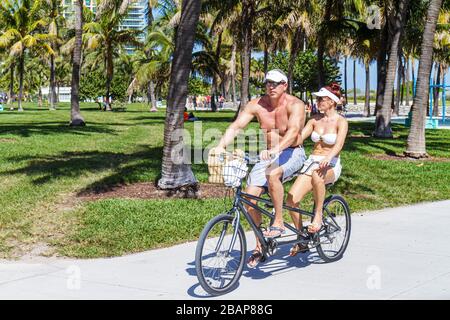 Miami Beach Florida, Lummus Park, Serpentine Trail, Erwachsene Erwachsene Männer Männer Männer, Frau Frauen weibliche Dame, Badeanzug, Tandem, Fahrrad, Radfahren, Reiten, Radfahren Stockfoto