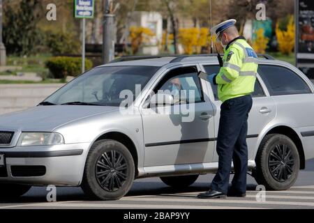 Bukarest, Rumänien. März 2020. Ein Polizist prüft einen Autofahrer auf Papiere zu seiner Bewegung in Bukarest, Rumänien, 28. März 2020. Rumänien kündigte am Mittwochmorgen eine landesweite Sperrung an, nachdem eine Ausgangssperre, die seit Sonntagabend eingeführt worden war, vorlag. Das Land trat am 16. März in den Notstand, nachdem die Zahl der COVID-19-Fälle 100 überschritten hatte. Credit: Cristian Cristel/Xinhua/Alamy Live News Stockfoto