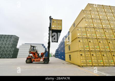 Zhangzhou, Chinas Provinz Fujian. März 2020. Am 28. März 2020 wird ein Container in Zhangzhou China International Marine Containers (Group) Ltd. (CIMC) in Zhangzhou in der südsüdchinesischen Provinz Fujian gehoben. Das Unternehmen beschleunigt die Wiederaufnahme von Arbeit und Produktion mit epidemischen Präventionsmaßnahmen gegen COVID-19. Mehr als 90 Prozent der Mitarbeiter sind auf ihre Posten zurückgekehrt. Kredit: Jiang Kehong/Xinhua/Alamy Live News Stockfoto