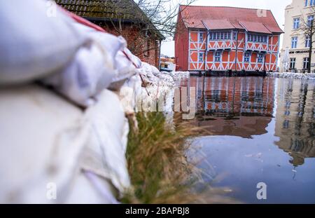 Wismar, Deutschland. März 2020. Über dem überfluteten Mühlenstrom steht ein historisches Fachwerkhaus, an dessen Ufern Sandsäcke angelegt sind. Das Hochwasser der Ostsee schiebt das Wasser in den Bach und bewirkt einen Anstieg des Wasserpegels. Eine Sturmflut an der Ostseeküste verursacht Hochwasser, der Sturmflutwarndienst erwartet Wasserstände zwischen 1 und 1,30 Meter über dem mittleren Wasserstand im gesamten Küstengebiet. Kredit: Jens Büttner / dpa-Zentralbild / dpa / Alamy Live News Stockfoto