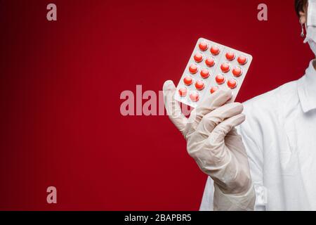 Frau in Handschuhen mit Pillen im Studio Stockfoto