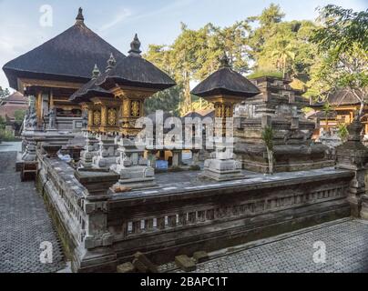 Innenhof des Heiligen Wasser Tempels in Bali Indonesien mit goldenen Tempelstrukturen und schwarzen Dächern in frühen Morgenstunden Licht ohne Menschen. Stockfoto