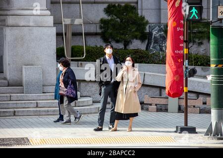 Attraktives junges Paar, das während der Coronavirus Pandemie, Seoul, Südkorea Masken trägt Stockfoto