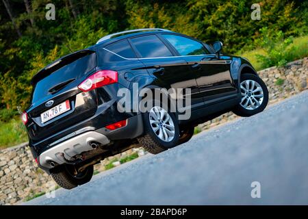 Ford Kuga SUV, schwarze Metallic-Farbe, Panorama-Decke, Geländewagen, Automatikgetriebe, isoliert auf einem leeren Parkplatz, Fotoshooting Stockfoto