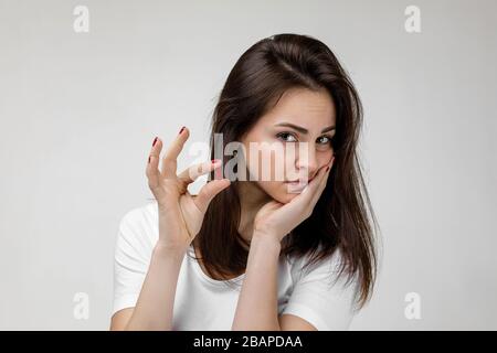 Junge traurige Frau mit Arznei, die unter Zahnschmerzen, Karies leidet. Mädchen mit Zahnschmerzen und Tablette. Konzept für Zahngesundheit und -Pflege Stockfoto