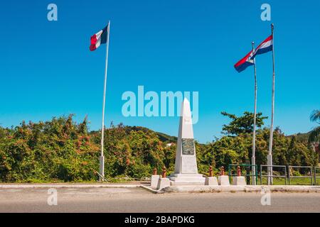 Flaggen fliegen am Denkmal der Einheit und Freundschaft an der Grenze zwischen der französischen und niederländischen Seite der Karibikinsel St. Martin / St. Maarten Stockfoto