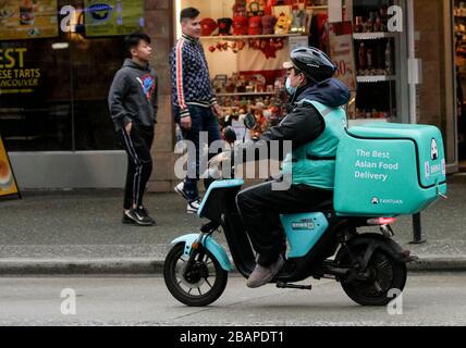 Vancouver, Kanada. März 2020. Ein Lebensmittelzusteller reitet am 28. März 2020 in Vancouver, Kanada. Kredit: Liang Sen/Xinhua/Alamy Live News Stockfoto