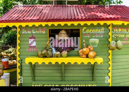 Ocho Rios, Jamaika - 22. April 2019: Eiskalte Kokosnuss-Fruchtsgetränke mit Rum-Stall/Eck-Shop in Rasta-Farben am Kreuzfahrthafen Ocho Rios in der Stockfoto