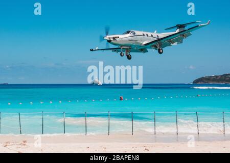 Ein Tradewinds Pilatus PC-12 macht eine "über den Strand" Start- und Landebahn 28 Ansatz am Saint Barthélemy Airport, Französisch Karibik Stockfoto