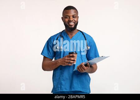 Glücklicher schwarzer Arzt mit medizinischer Karte mit Kaffeepause Stockfoto