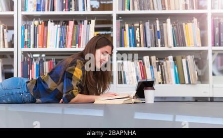 Junge Studentin, die in der Bibliothek studiert Stockfoto