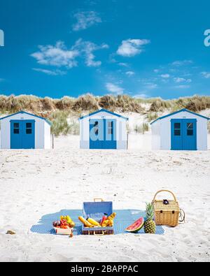 Picknick am Strand Texel Niederlande, Paar mit Picknick am Strand von Texel mit weißem Sand und farbenfrohem Haus Stockfoto
