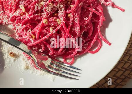 Spaghetti-Pasta mit rosafarbenen Rote-Bete-Sause in einer weißen Schüssel Stockfoto