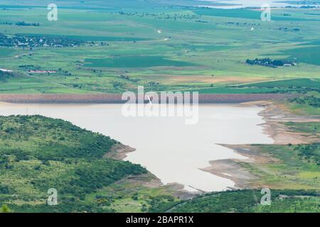 Luftbild über einen großen Staudamm oder ein Wasserspeicher in Kwazulu Natal, Südafrika während der grünen und feuchten Sommersaison mit landschaftlich schöner Landschaft Stockfoto