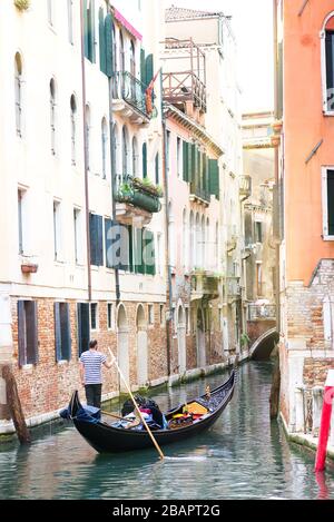 Die Gondeln der Männer fahren mit Touristen in Venedig in Italien in Gondeln. Stockfoto