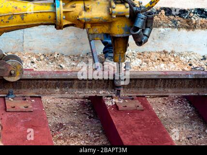 Bahnarbeiter, die die Gleisschiene verschrauben. Detailarbeiter mit mechanischem Schraubenschlüssel Stockfoto