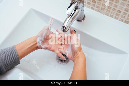 Frau, die ihre Hände im Badezimmer mit Seife und Wasser waschen. Reinigung der Handhygiene zur Vorbeugung von Coronavirus-Ausbrüchen. Schutz vor Corona-Virus-Pandemie Stockfoto