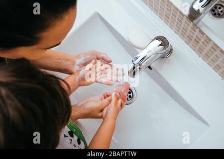 Mutter und Sohn waschen ihre Hände mit Seife und Wasser im Badezimmer. Reinigung der Handhygiene, um den Ausbruch von Coronavirus zu verhindern. Schutz Agai Stockfoto