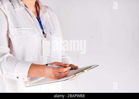 Hand einer Frau, die die Checkliste in einer Zwischenablage ausfüllt, Platz kopieren Stockfoto