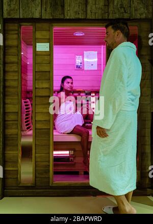 Ein Paar in der Sauna, Männer und Frauen im bademantel, die eine heiße Sauna besuchen Stockfoto