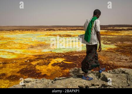 Ein Mann spaziert auf Schwefel- und Mineralsalzformationen in der Nähe von Dallol in der Danakil-Depression im Norden Äthiopiens am 22. April 2013. Stockfoto