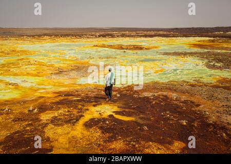 Ein Mann spaziert auf Schwefel- und Mineralsalzformationen in der Nähe von Dallol in der Danakil-Depression im Norden Äthiopiens am 22. April 2013. Stockfoto