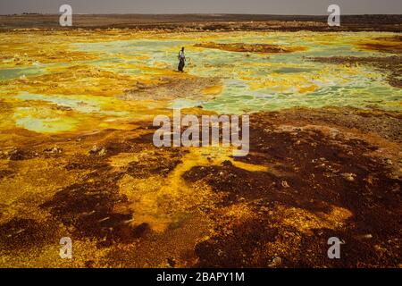 Ein Mann spaziert auf Schwefel- und Mineralsalzformationen in der Nähe von Dallol in der Danakil-Depression im Norden Äthiopiens am 22. April 2013. Stockfoto