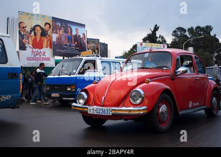 Old Red Beetle auf der Fahrt durch die Straßen der Innenstadt von Addis Abeba. Die bevölkerungsreichste Stadt Äthiopiens mit 3.384.569 Einwohnern Stockfoto