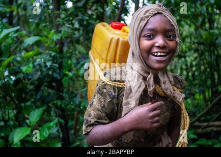 Debre Sina Beta Maryam Kirche, Lake Tana, Bahir dar, Äthiopien. Ein Mädchen sammelt Wasser aus einem nahe gelegenen Brunnen, um sie neben Debram Maryam Monaste nach Hause zu nehmen Stockfoto