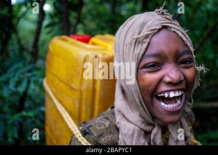 Debre Sina Beta Maryam Kirche, Lake Tana, Bahir dar, Äthiopien. Ein Mädchen sammelt Wasser aus einem nahe gelegenen Brunnen, um sie neben Debram Maryam Monaste nach Hause zu nehmen Stockfoto