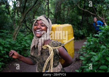 Debre Sina Beta Maryam Kirche, Lake Tana, Bahir dar, Äthiopien. Ein Mädchen sammelt Wasser aus einem nahe gelegenen Brunnen, um sie neben Debram Maryam Monaste nach Hause zu nehmen Stockfoto