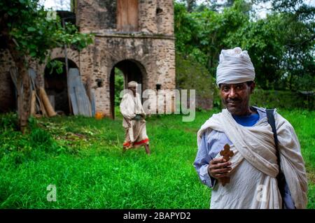 Debre Sina Beta Maryam Kirche, Lake Tana, Bahir dar, Äthiopien. Ein Priester posiert majestätisch mit seinem Kreuz an der Tür des Klosters Birgida Maryam auf o Stockfoto