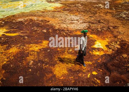 Ein Mann spaziert auf Schwefel- und Mineralsalzformationen in der Nähe von Dallol in der Danakil-Depression im Norden Äthiopiens am 22. April 2013. Stockfoto