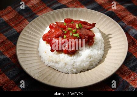 Foto von frisch gekochtem Tocino oder gehärtetem Schweinefleisch, serviert mit gebratenem Reis und Ei mit Gemüse. Stockfoto